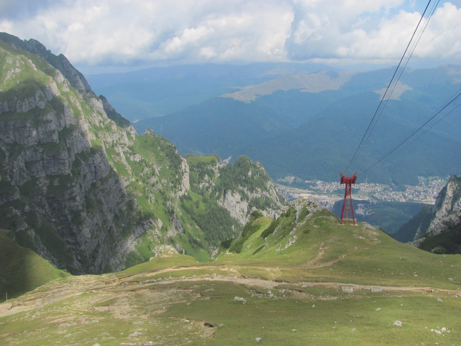 Die Seile führen über den Jepi-Abgrund an einem roten Mast vorbei hinab nach Bușteni im Tal
